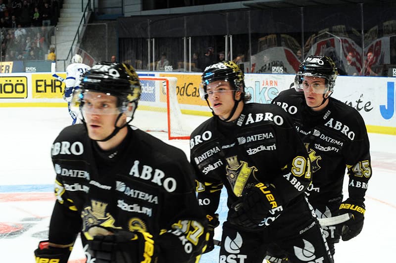 Tre ishockeyspelare på isen under en SHL-match